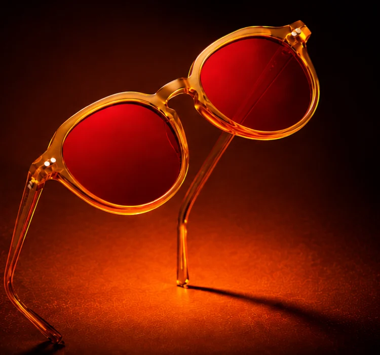 Armação cristal âmbar do Sync com lentes vermelhas, sobre fundo escuro